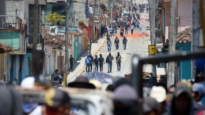 Residents and members of the new self-defense group known as 'El Machete' stand next to a burnt truck as others look for members of drug gangs and municipal authorities during a protest against the growing violence in the area, in Pantelho, in Chiapas state, Mexico 27 July, 2021