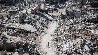 Editorial photo of destruction and a man walking with a bicycle in Gaza