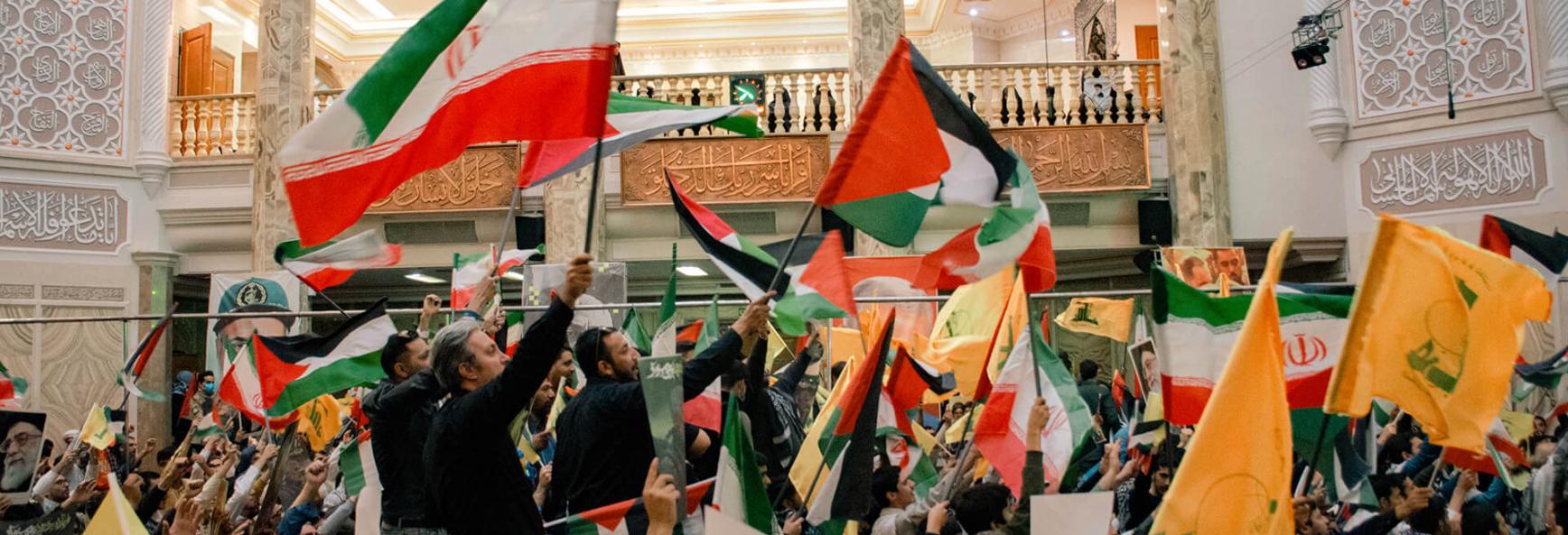 Participants raise flags and display images of Yahya Sinwar during the ceremony. Iran holds commemoration for Yahya Sinwar, with supporters gathering in Tehran on 24 October 2024.